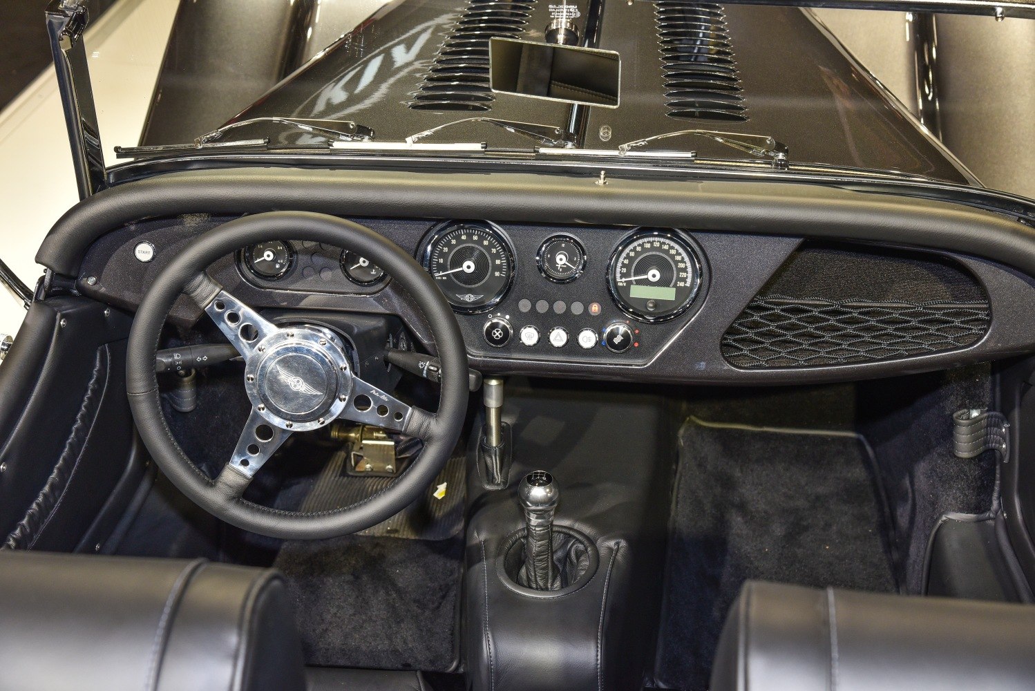 Dashboard with vintage-style gauges and leather-wrapped steering wheel