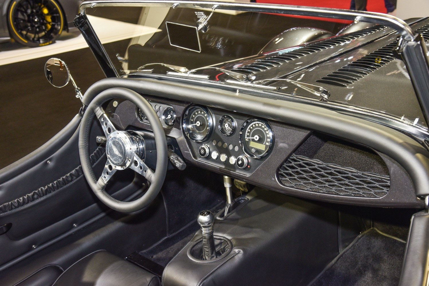 Classic car dashboard with analog gauges and manual gear shift.
