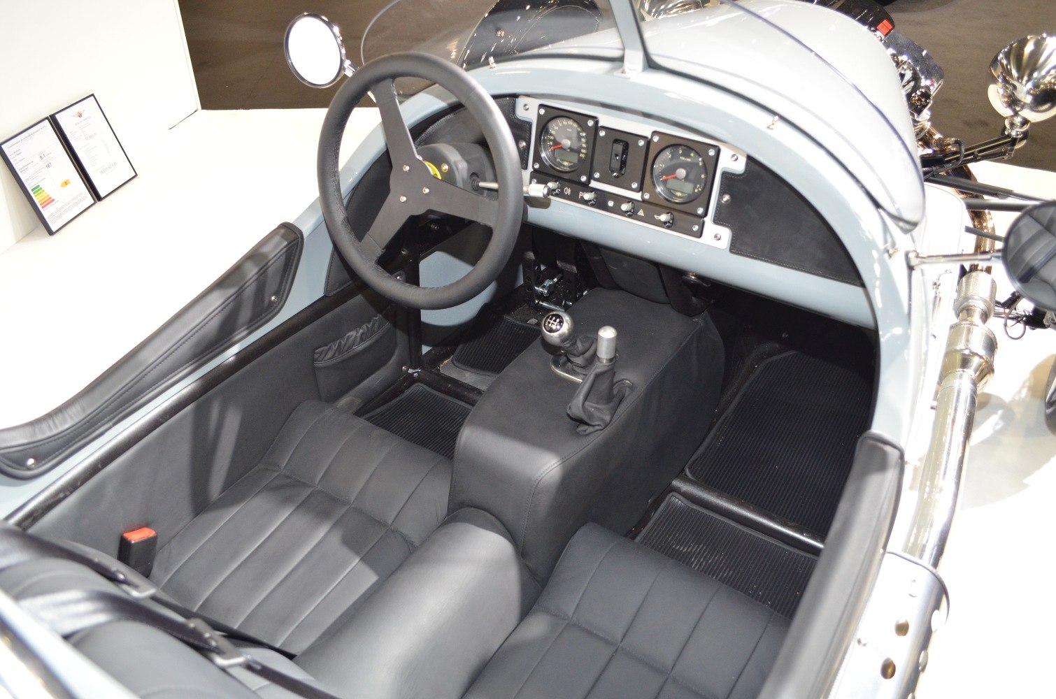 Dashboard, steering wheel, and seating interior of a retro vehicle