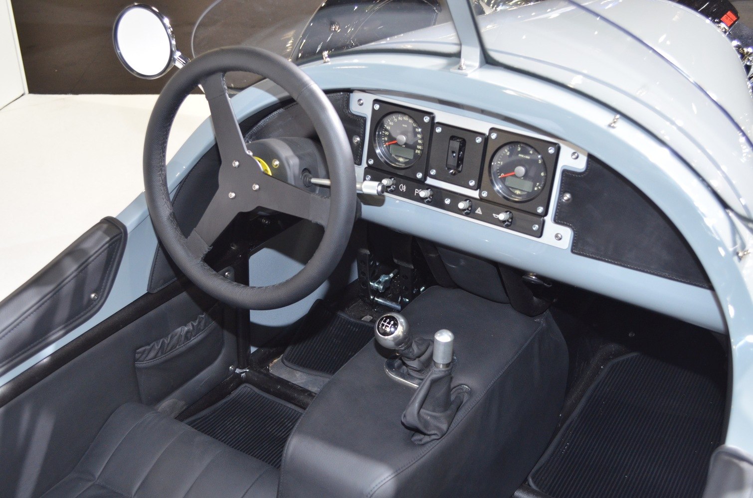 Classic dashboard with vintage steering wheel and manual gearshift.