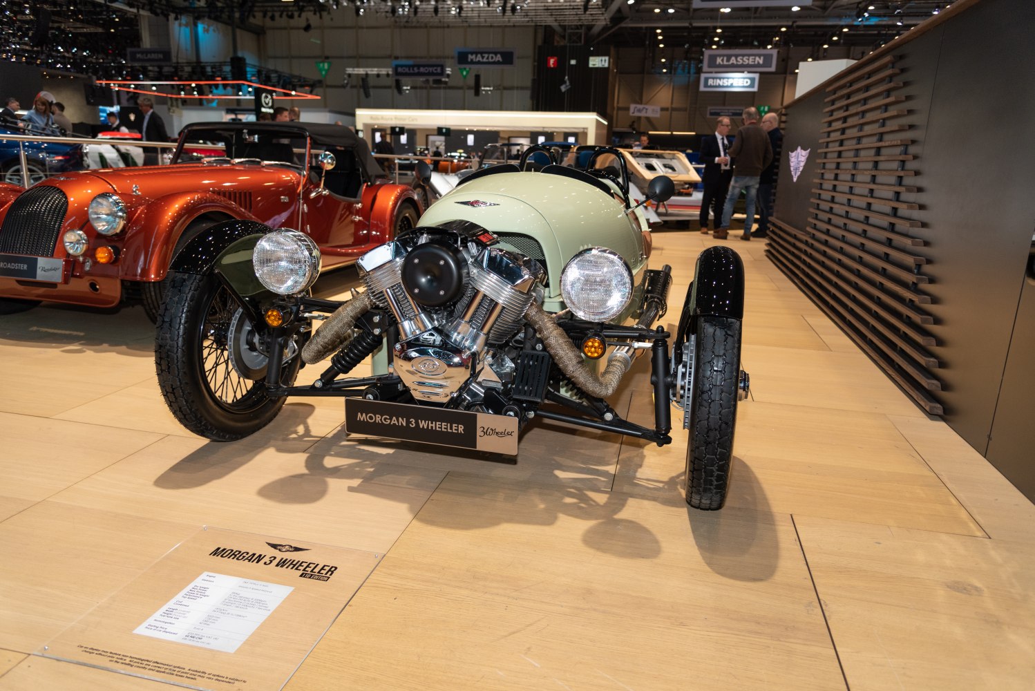 Three-wheeled vehicle with front-mounted exposed V-Twin engine and round headlights