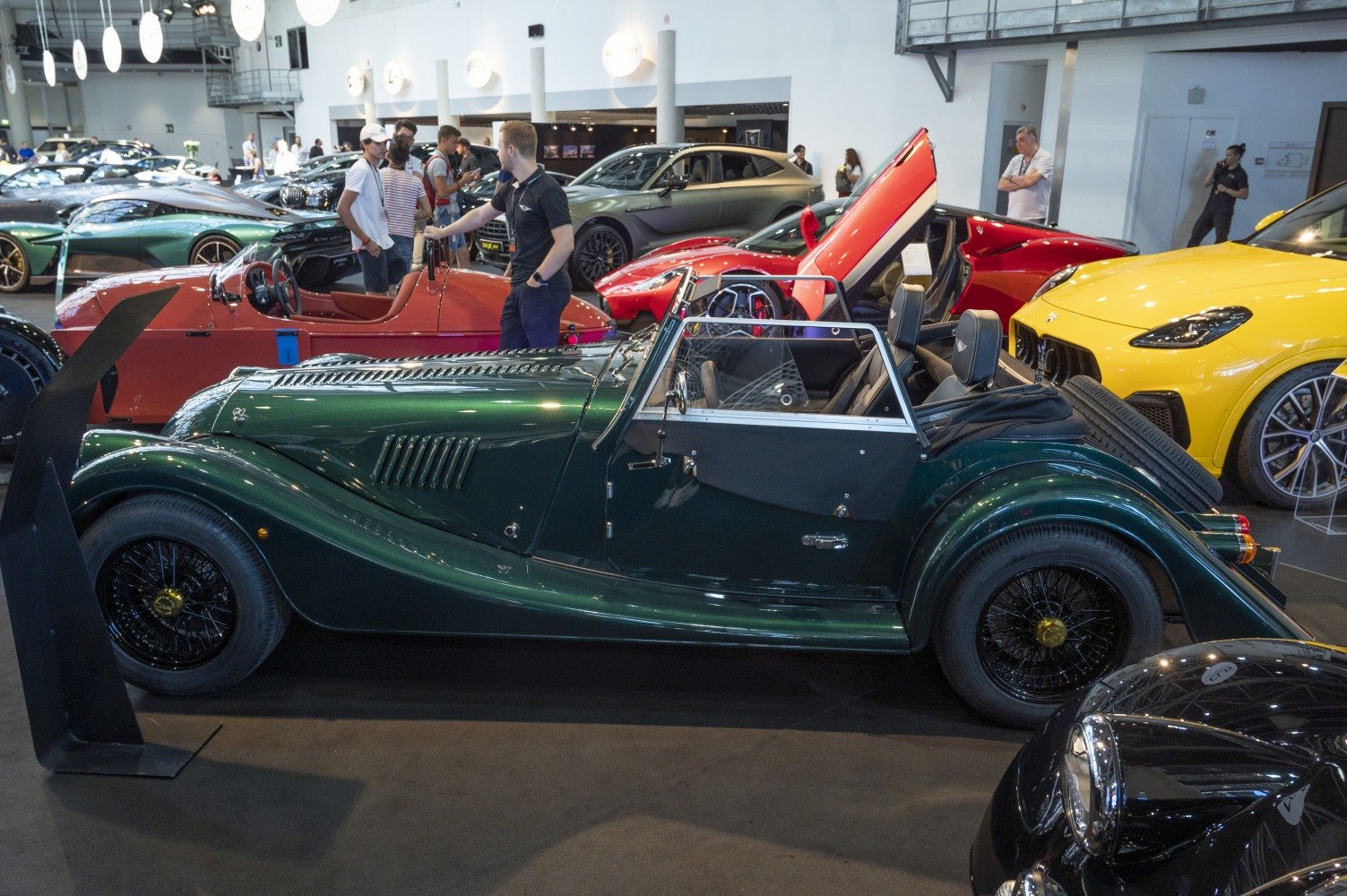 Vintage-style open-top roadster with wire-spoke wheels and long bonnet.