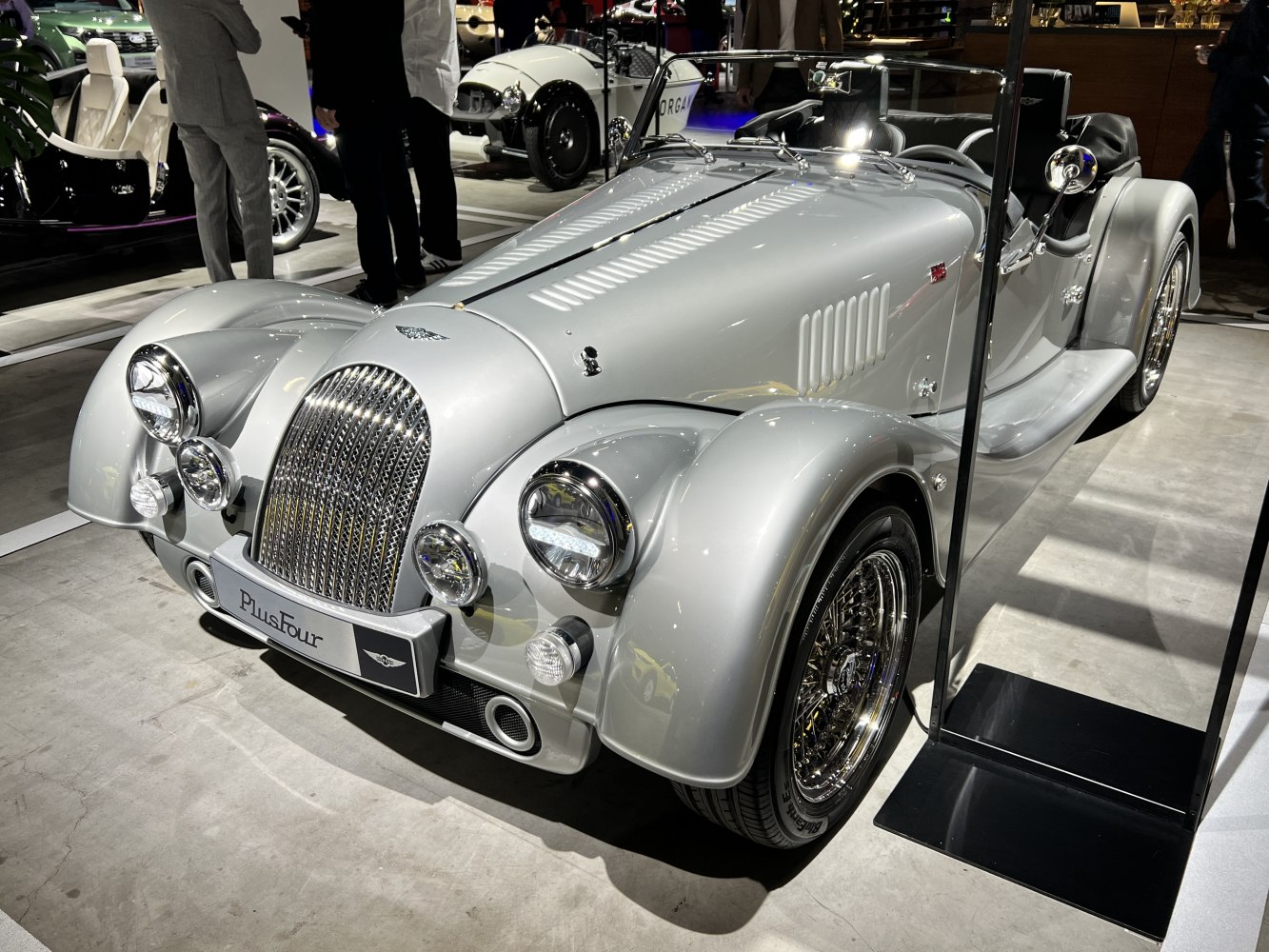 Classic roadster with chrome grille, rounded headlights, wire-spoke wheels