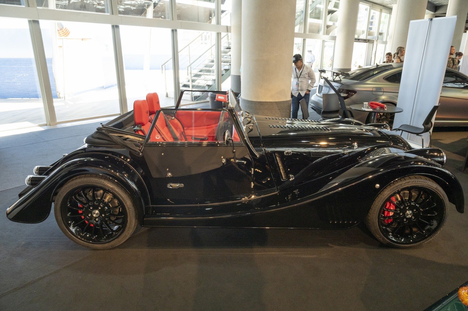 Vintage-style black roadster with red leather interior