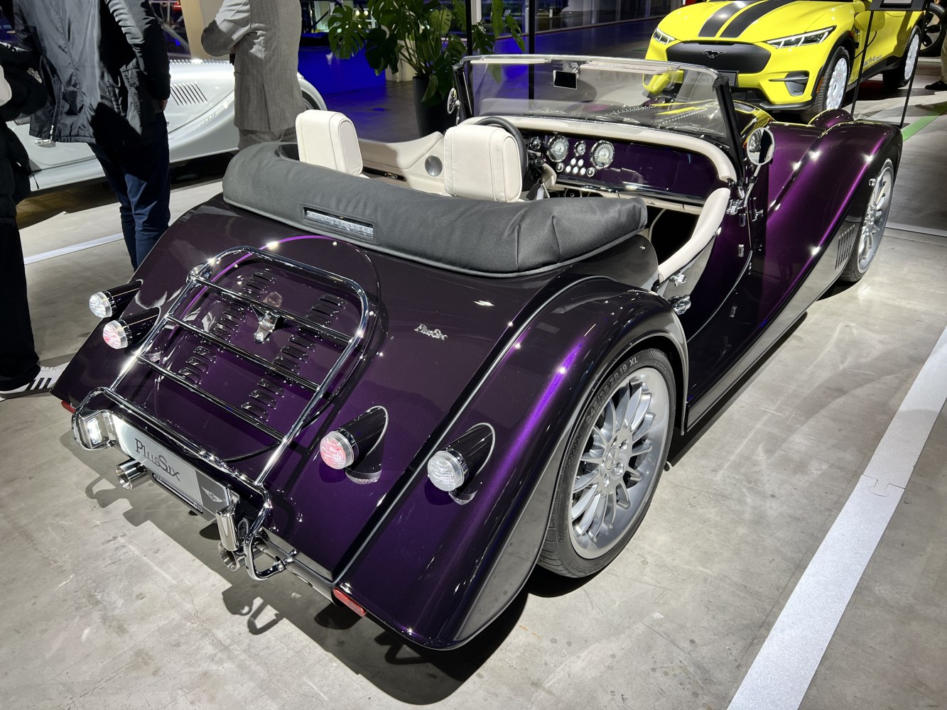 Rear view of a classic convertible roadster with chrome luggage rack and stylish rims