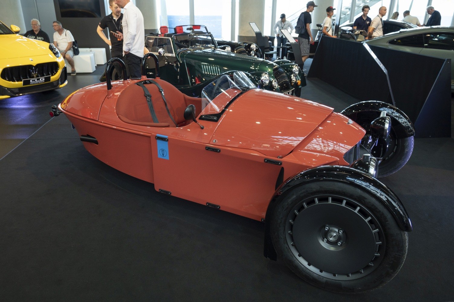 Three-wheeled vehicle with open cockpit and exposed front wheels