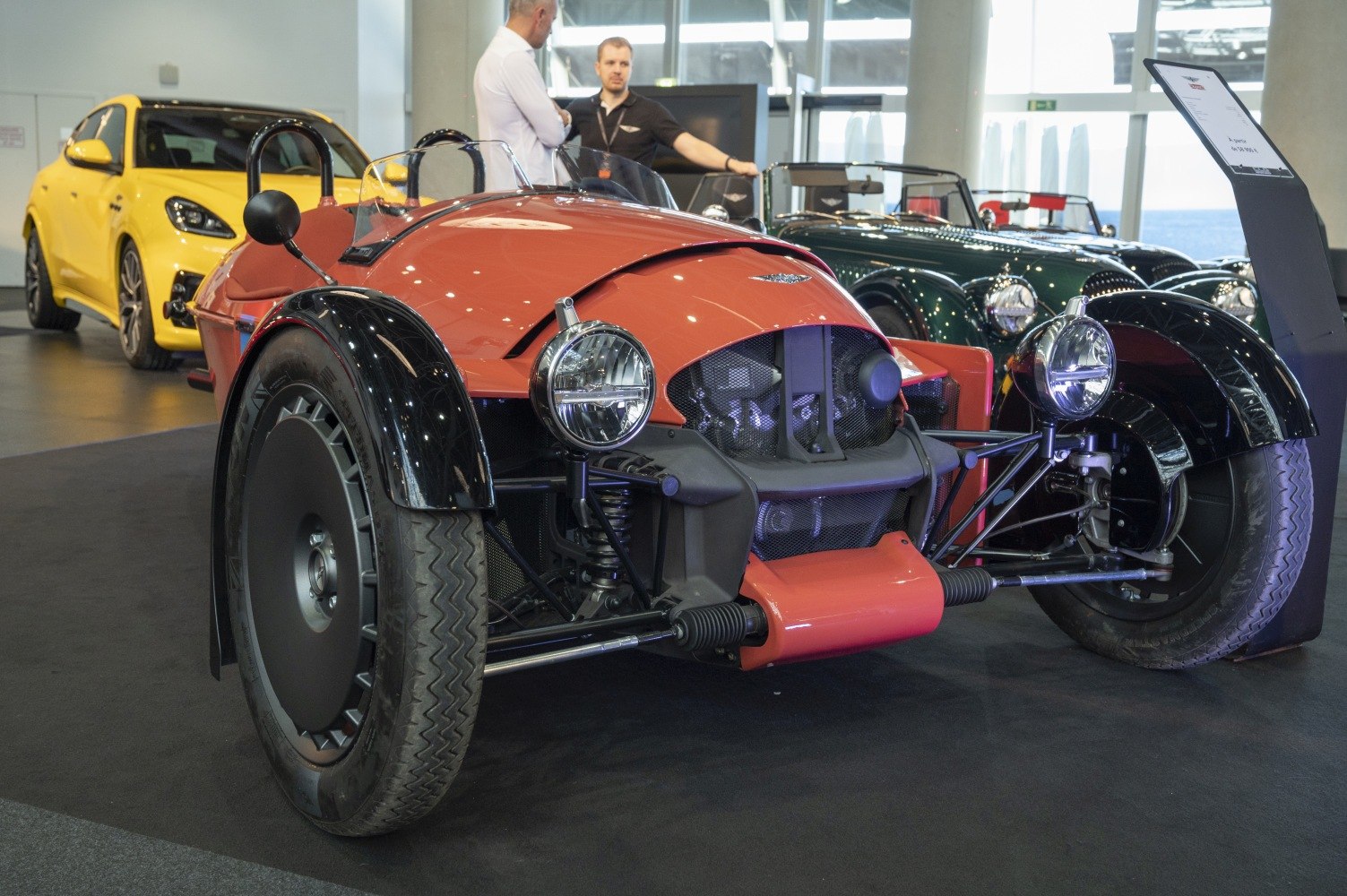 Open-wheel three-wheeler with retro headlights and exposed front suspension