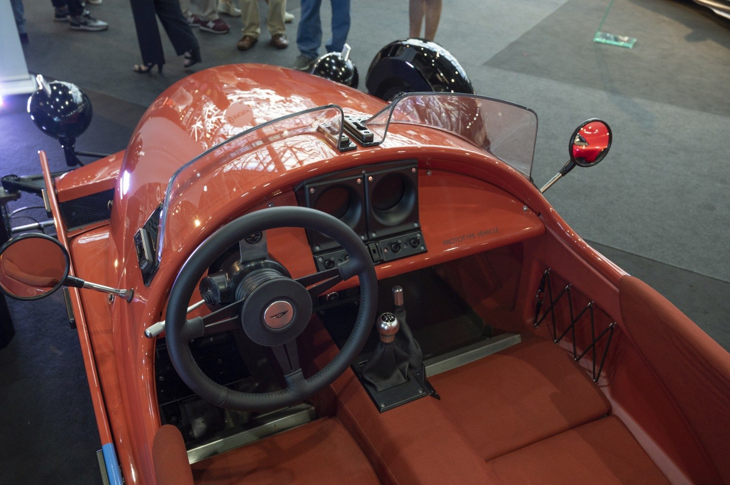Dashboard, steering wheel, and manual gear stick in open cockpit