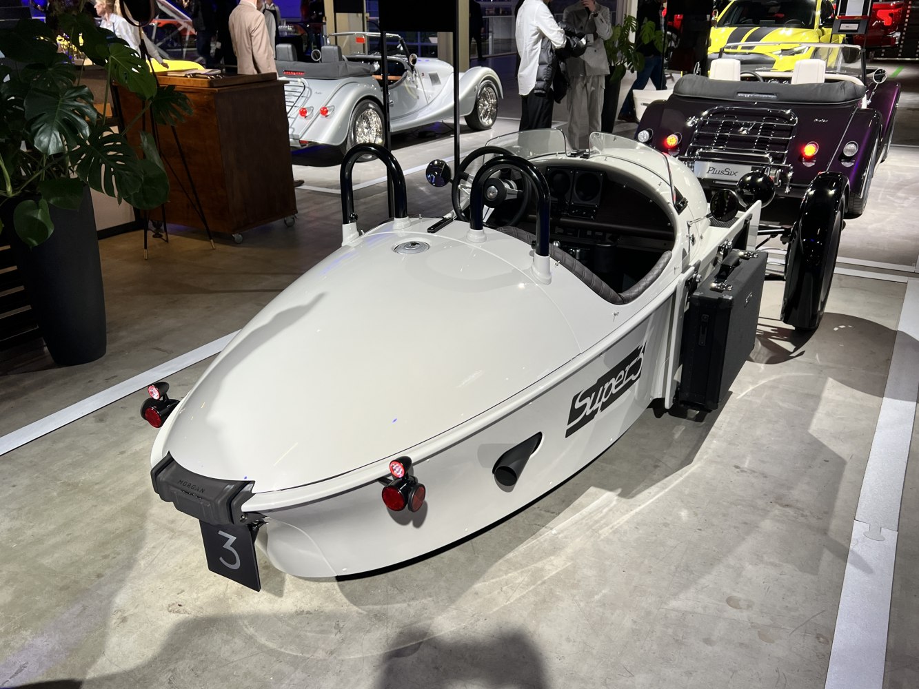 White three-wheeled vehicle with open cockpit and retro design