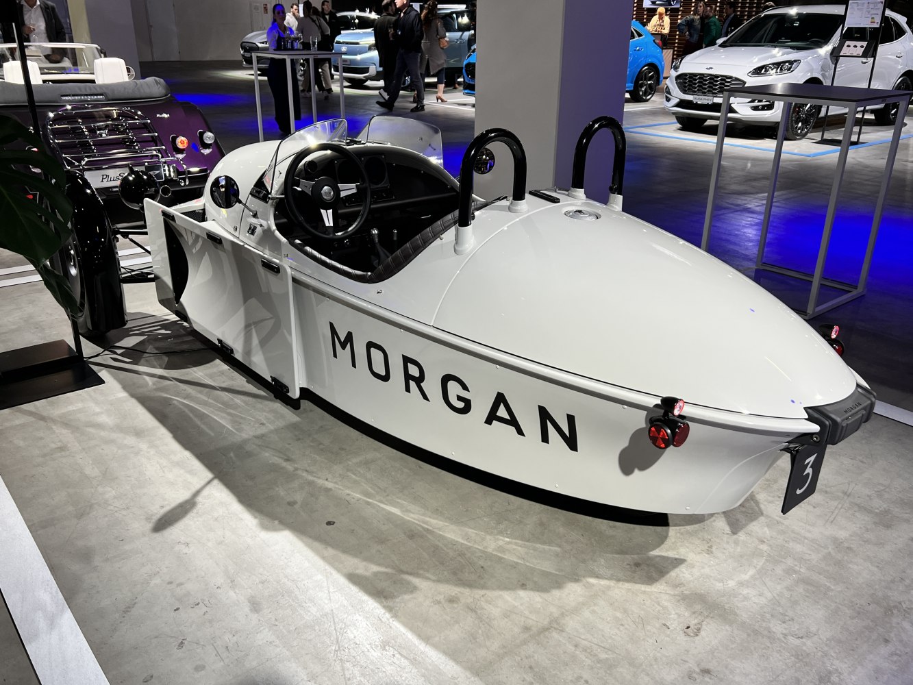 Three-wheeled vehicle with open cockpit and aerodynamic body