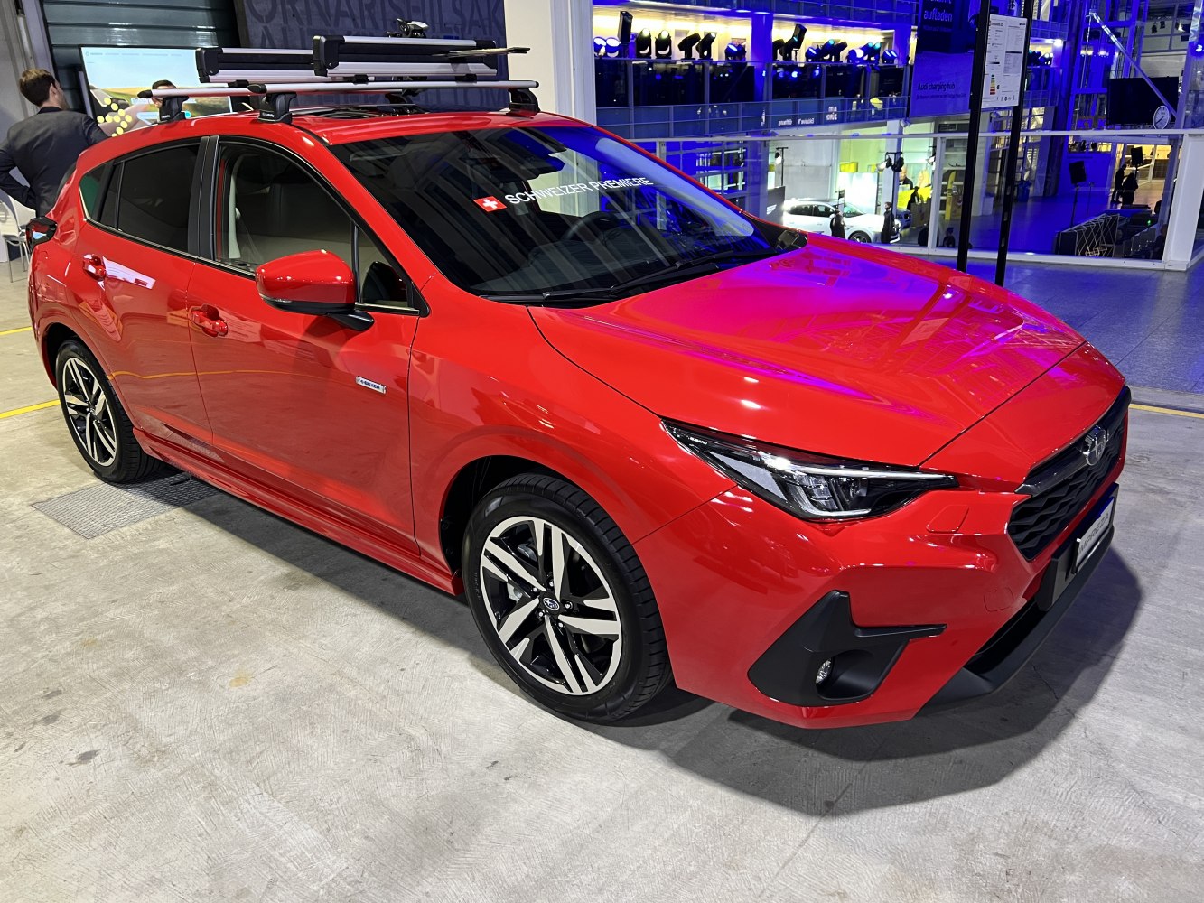 Hatchback with LED headlights and roof rack in red.