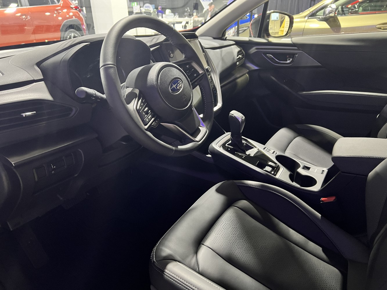 Black steering wheel and gear shift in modern car interior
