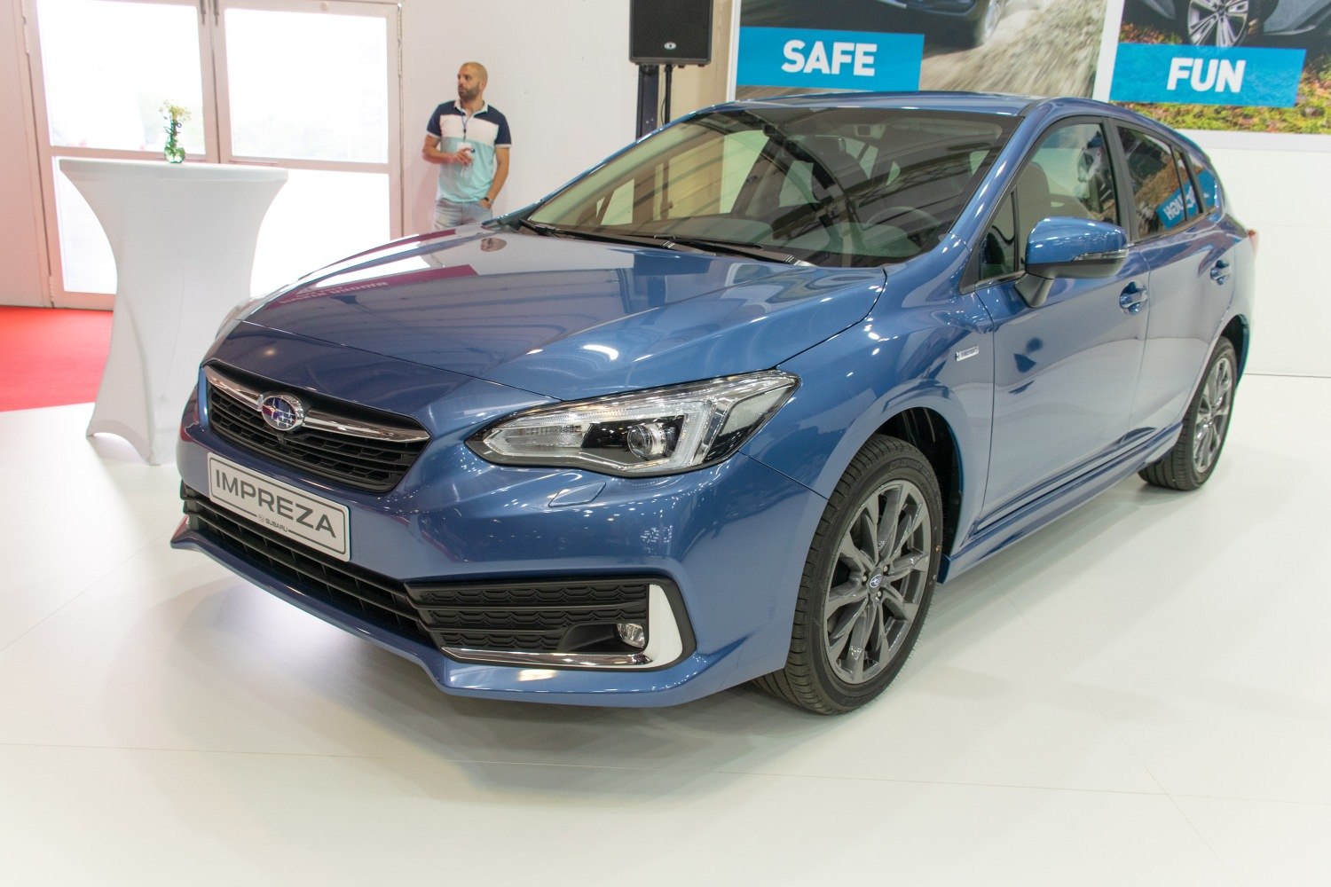 Front and side view of a blue hatchback with sleek headlights and alloy wheels