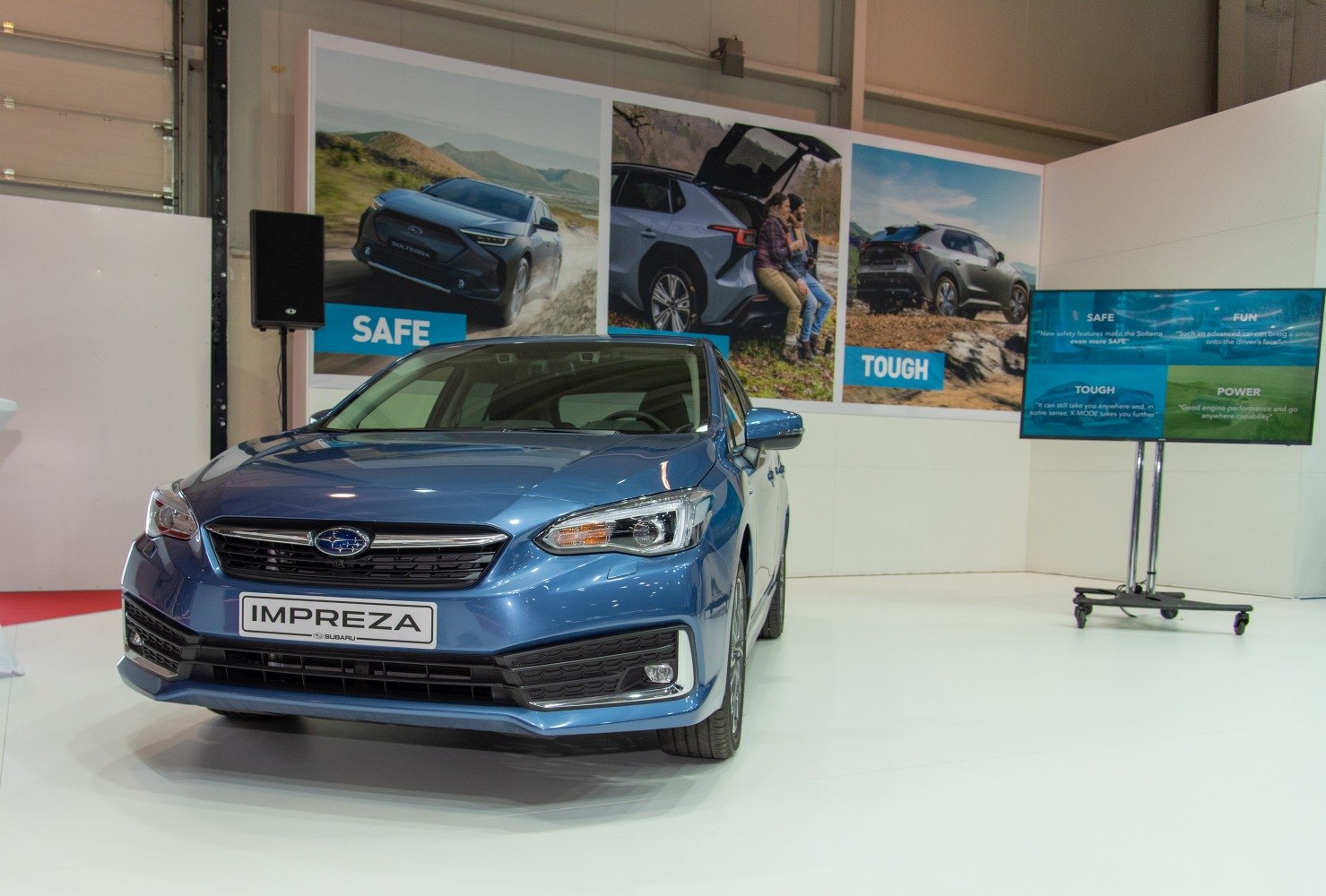 Front view of blue hatchback with sleek headlights and modern grille