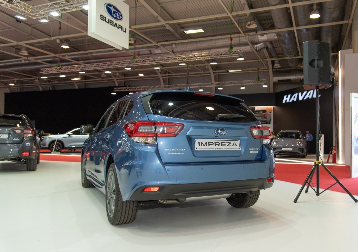 Rear view of a blue hatchback with distinct taillights and sporty design.