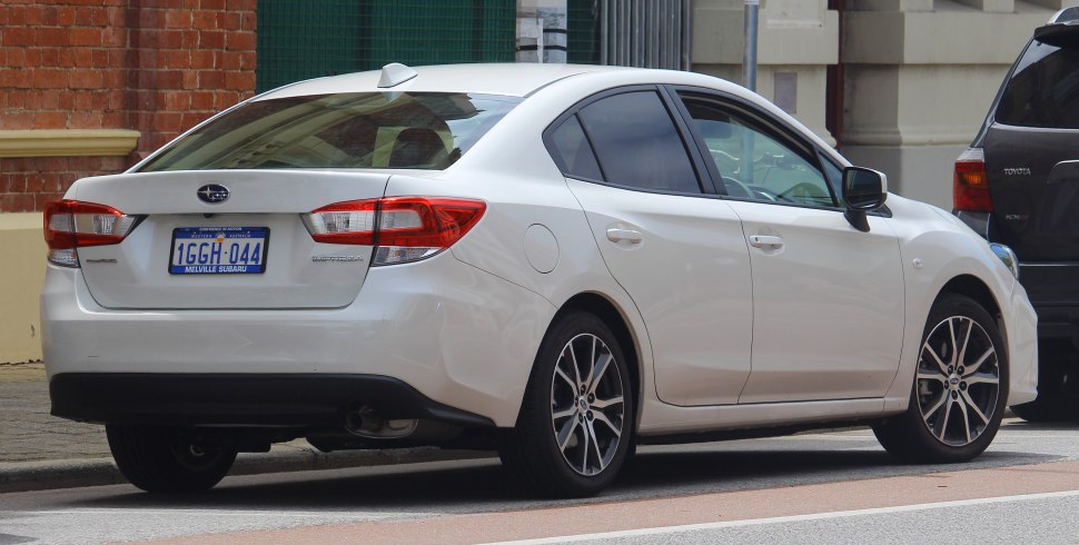 Rear side view of white sedan with alloy wheels