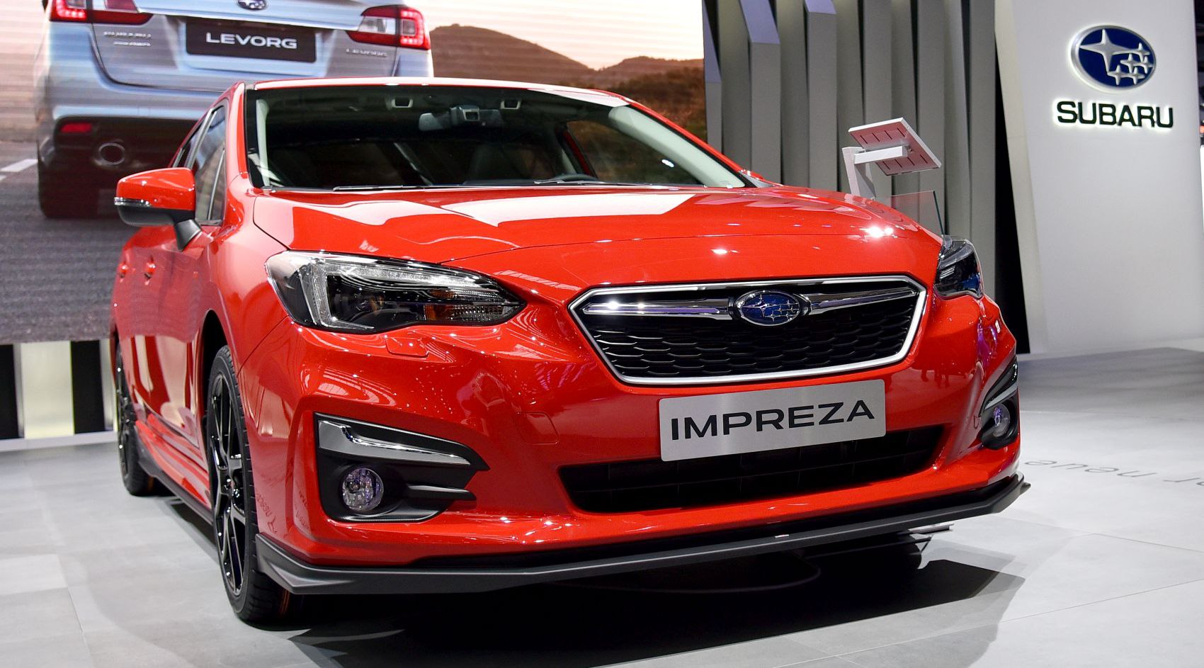 Front view of a red hatchback with LED headlights and bold grille