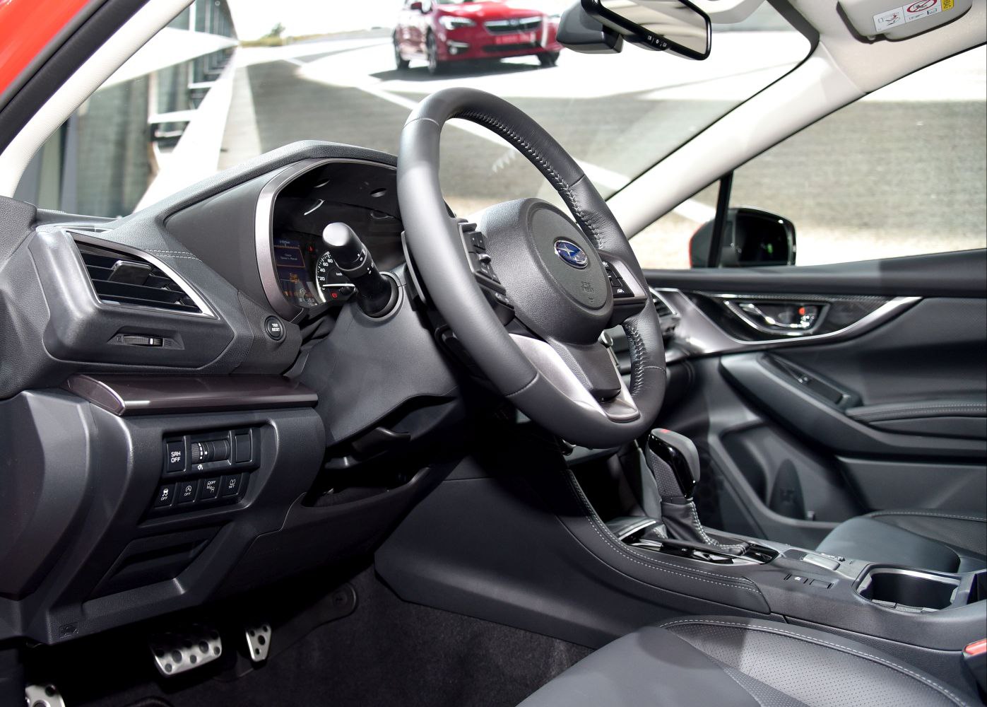 Steering wheel and dashboard close-up with gear shift and pedals in a car interior