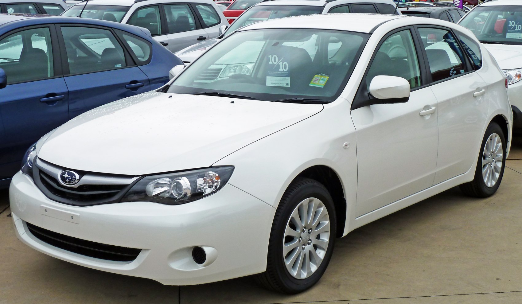 White compact hatchback with stylish headlights and alloy wheels
