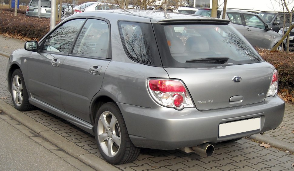 Rear view of a grey station wagon with alloy wheels and dual tailpipes.