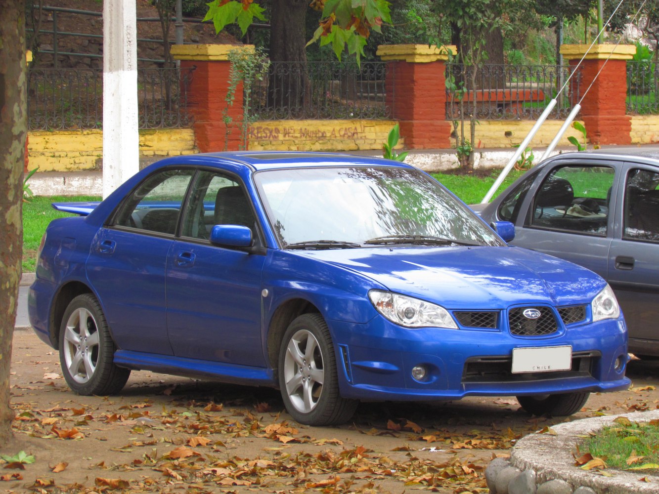 Blue compact sedan with rear spoiler and alloy wheels