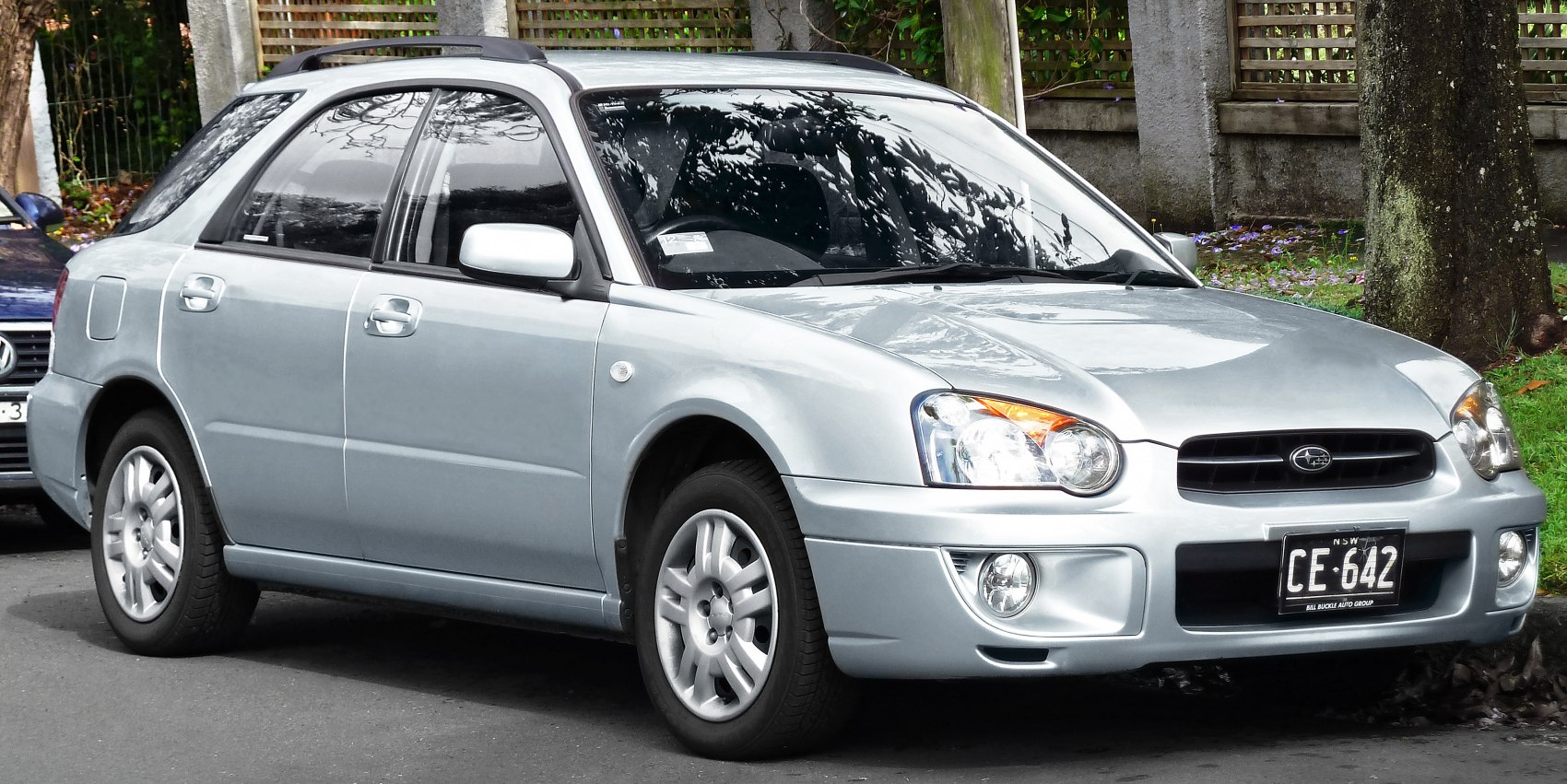 Front and side view of a silver station wagon with rounded headlights and alloy wheels