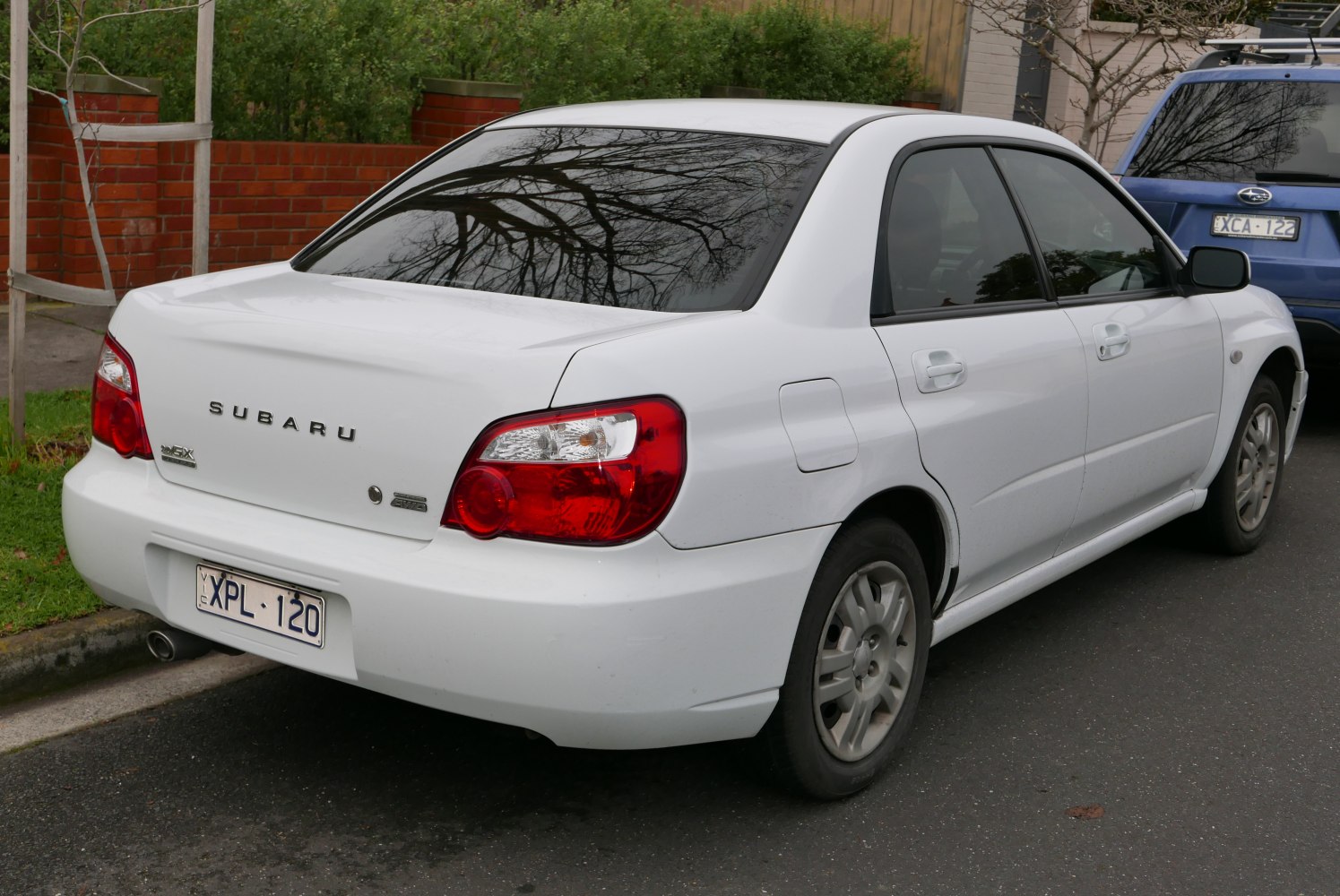 Rear view of a white sedan with distinctive taillights and four doors