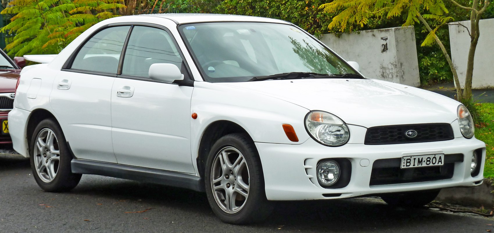 White sedan with oval headlights and rear spoiler