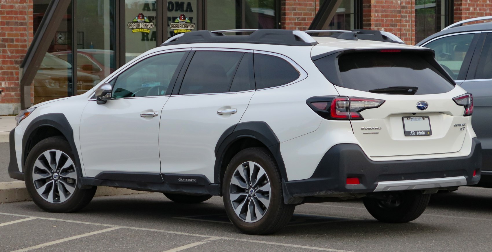 Rear and side view of a white SUV with roof rails, black cladding and modern tail lights