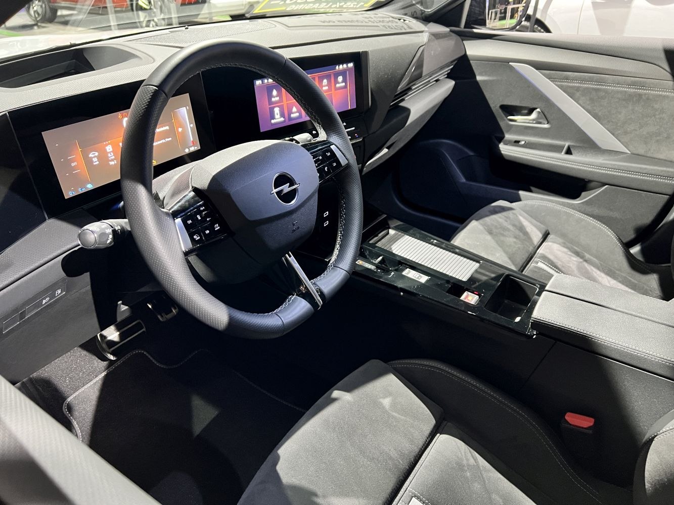 Digital instrument cluster and touchscreen display with ergonomic steering wheel interior