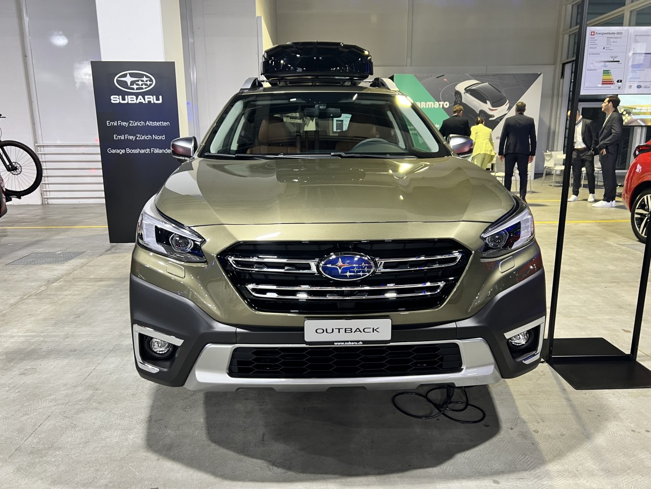 Front view of car with roof box, sleek headlights, and rugged grille
