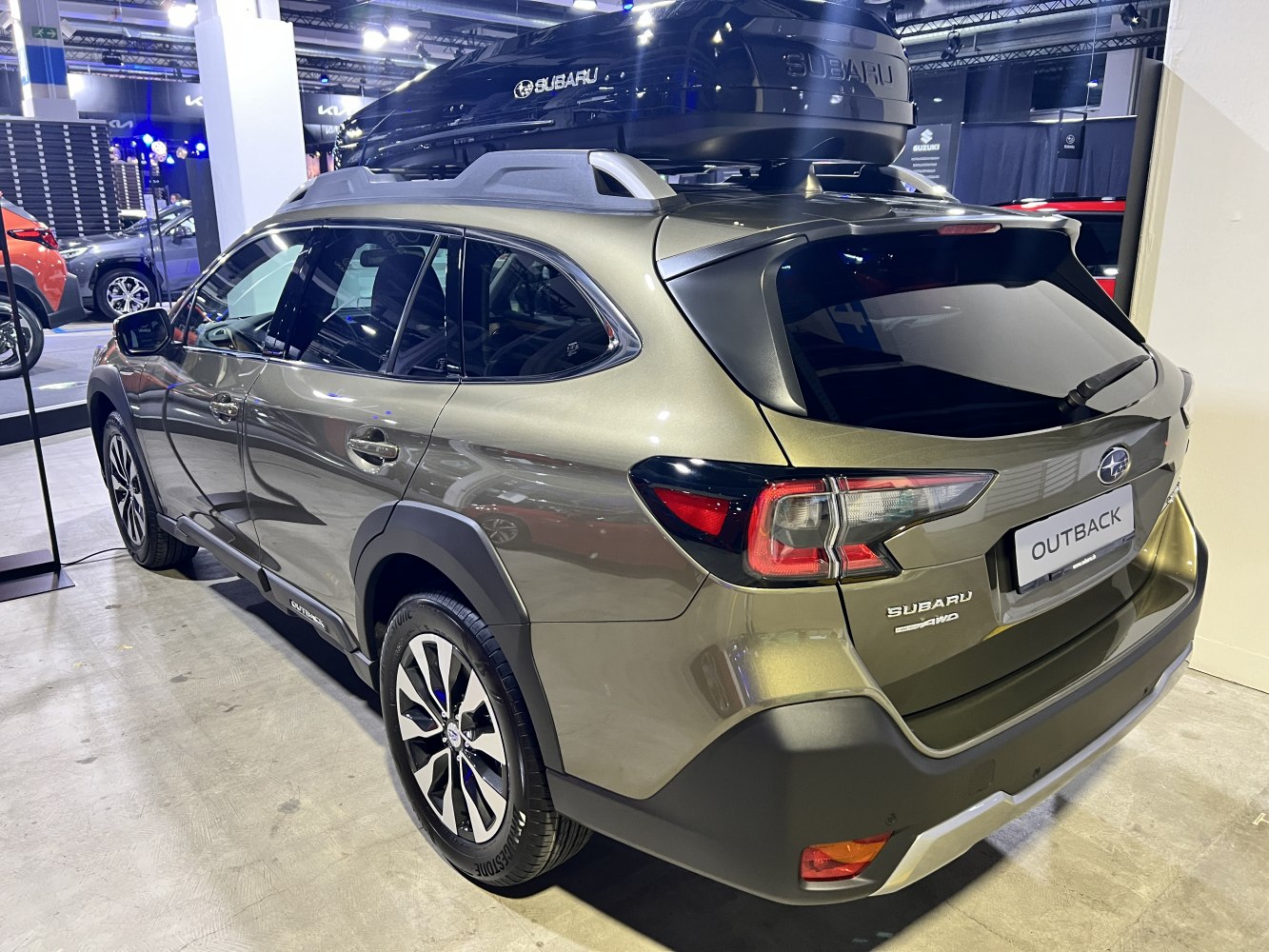Rear and side view of SUV with roof box and rugged styling
