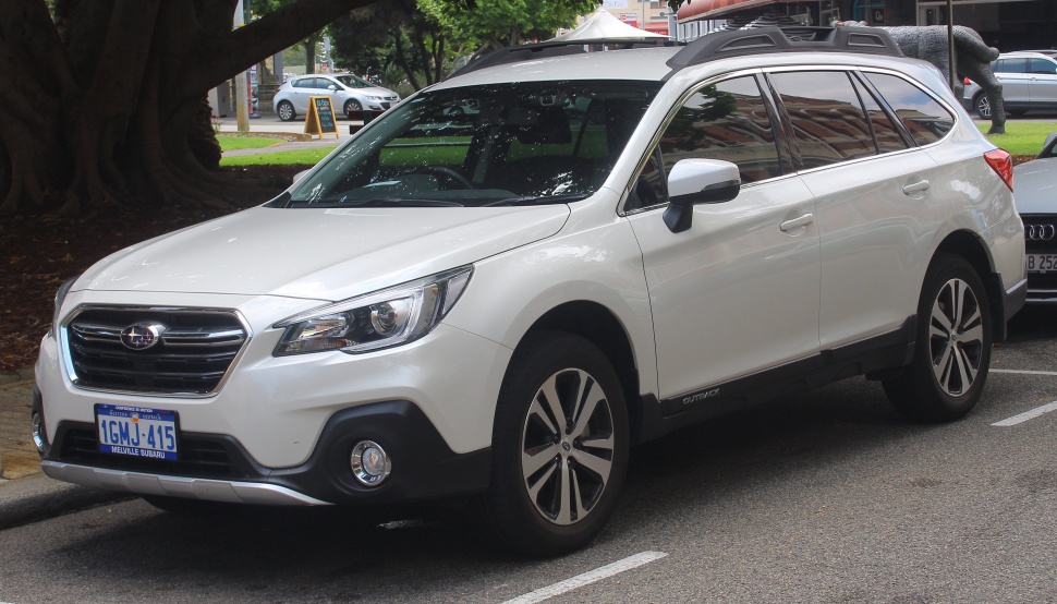 White SUV with prominent roof rails and alloy wheels