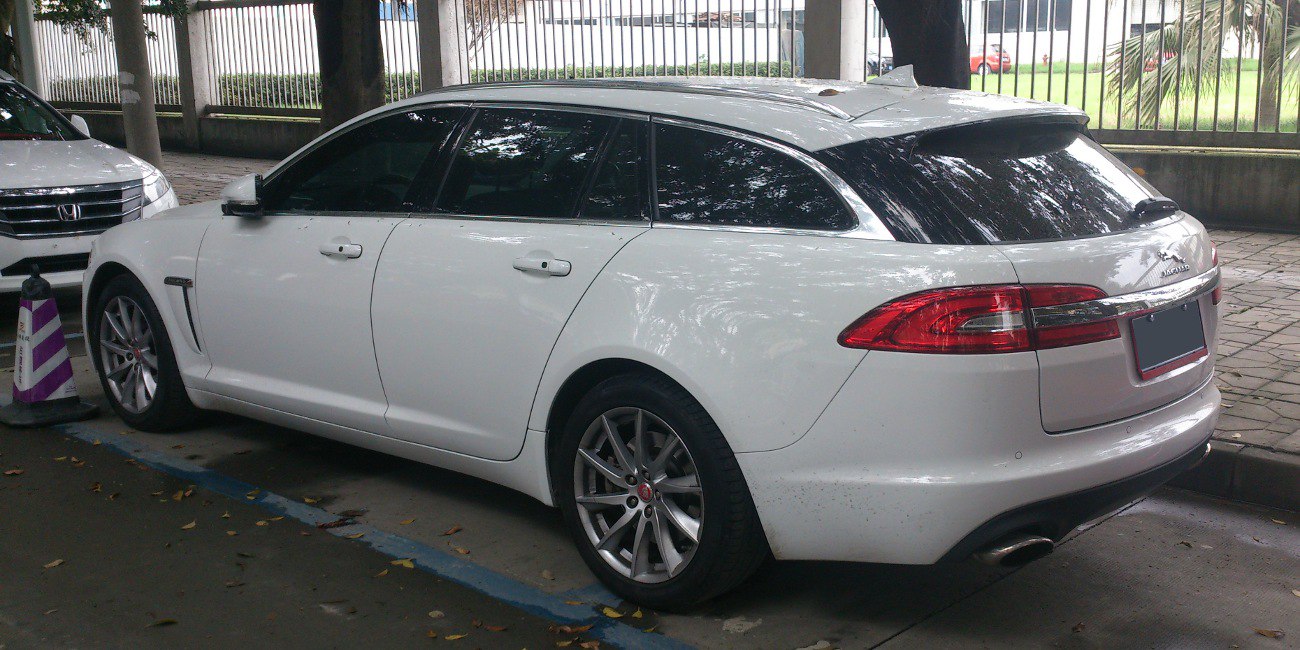 White station wagon rear side with alloy wheels and taillights