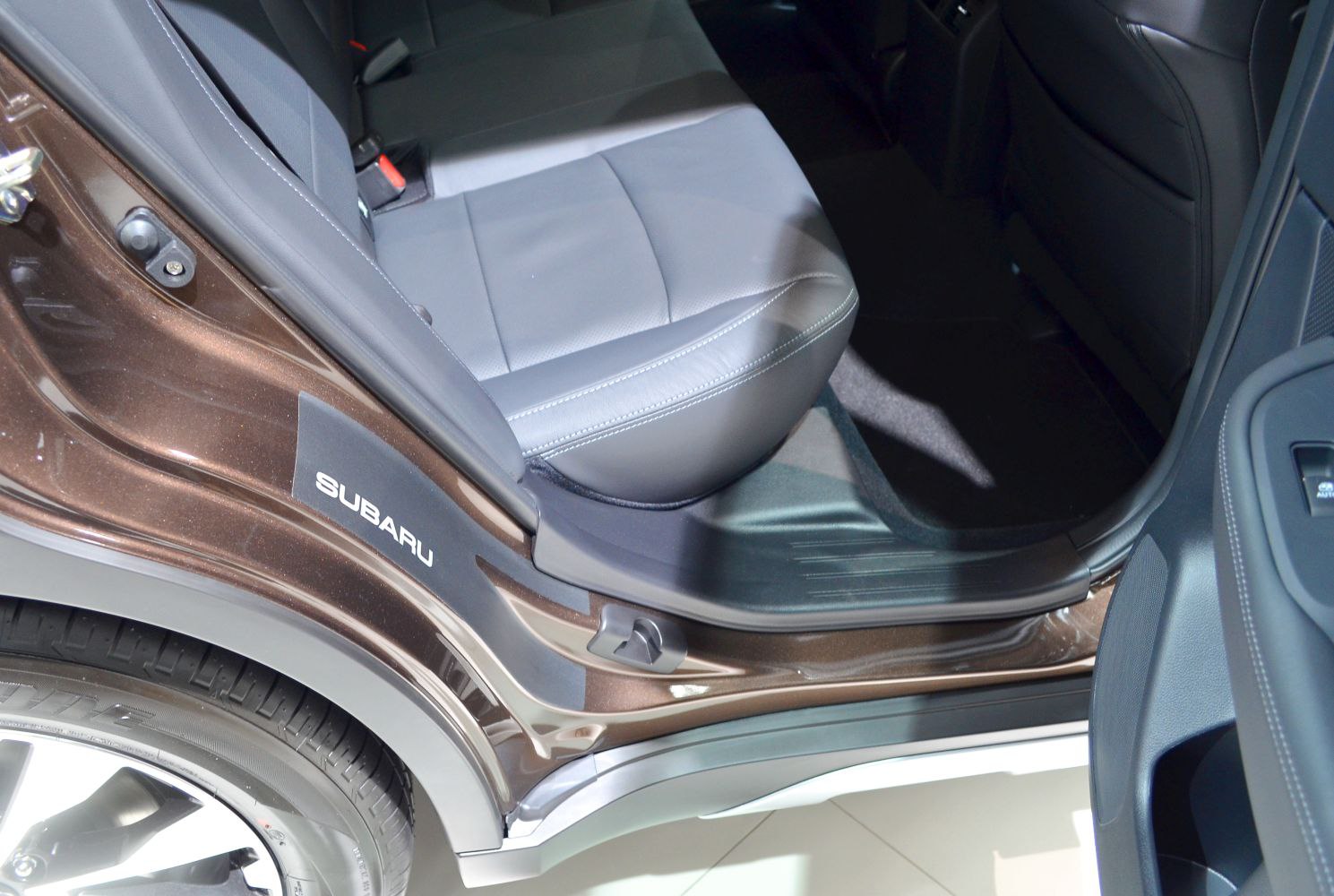 Rear passenger seat and door frame with tire edge and interior trim.