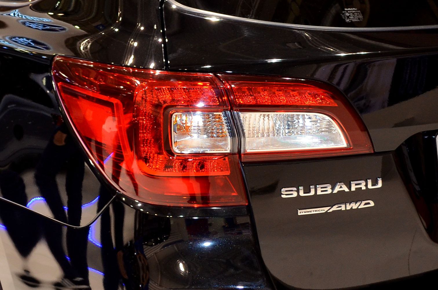 Close-up of rear tail light and AWD badge on black vehicle