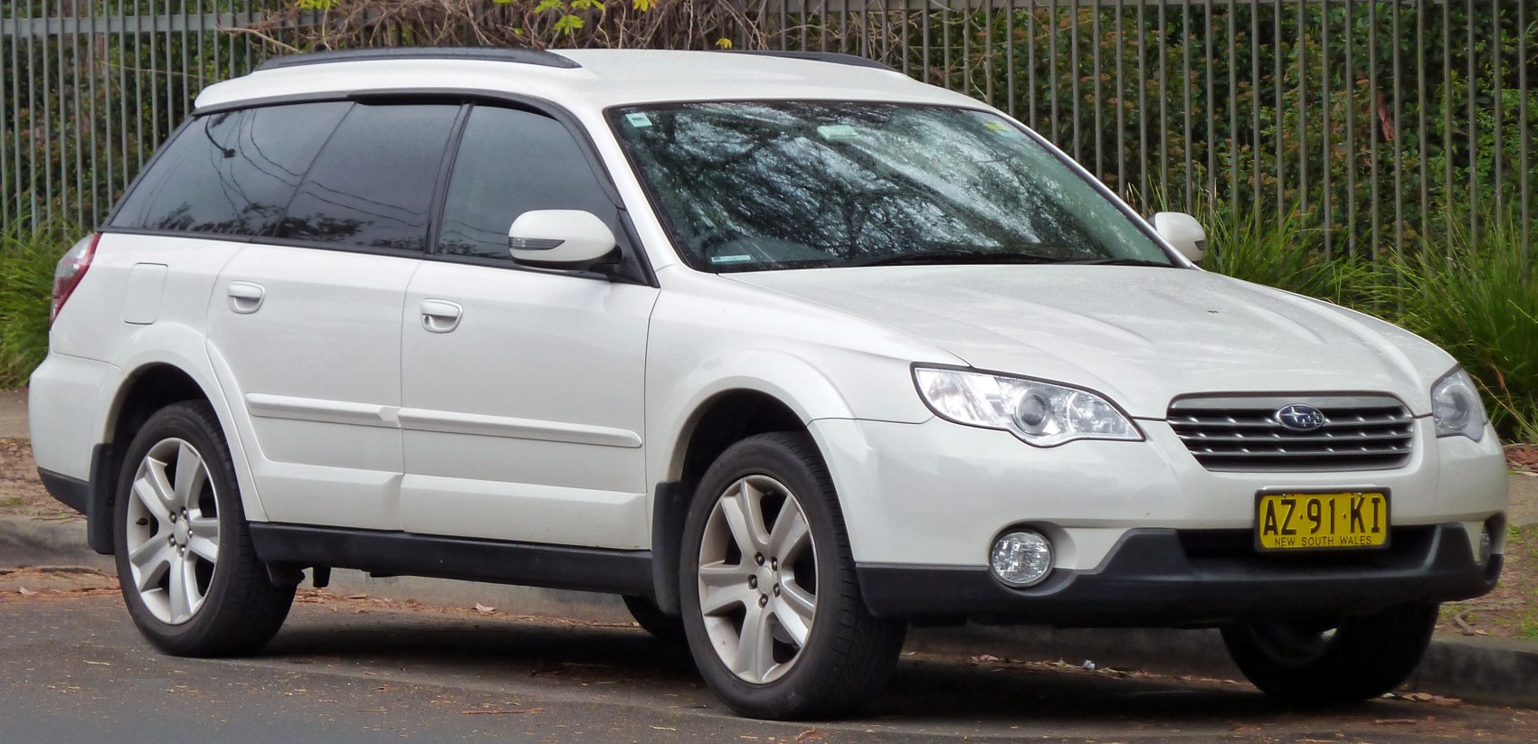 White station wagon with roof rails and alloy wheels front-side view
