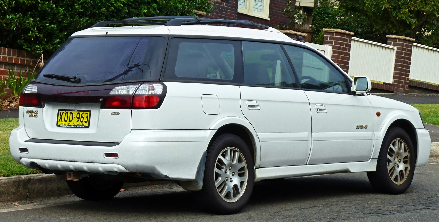White station wagon with roof rails and alloy wheels rear view