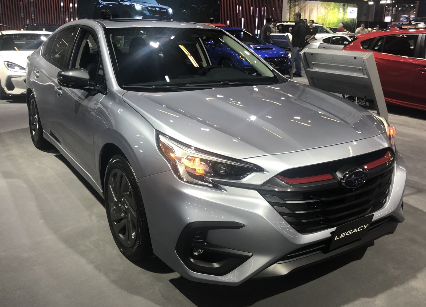 Silver sedan with sharp headlights and bold front grille design