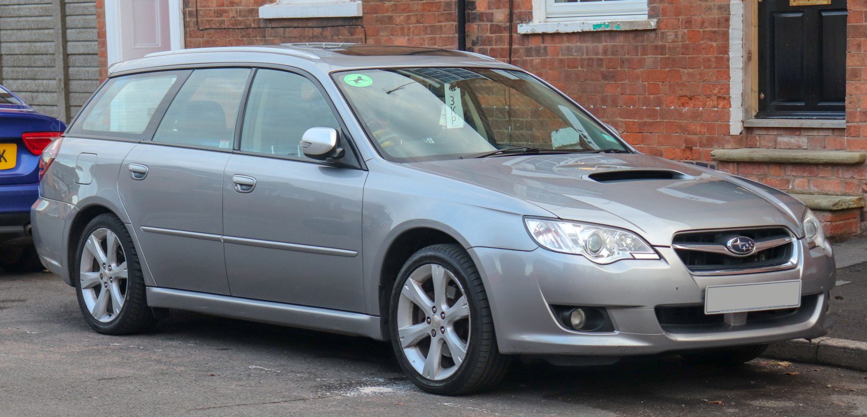 Silver station wagon with hood scoop and alloy wheels, front side view