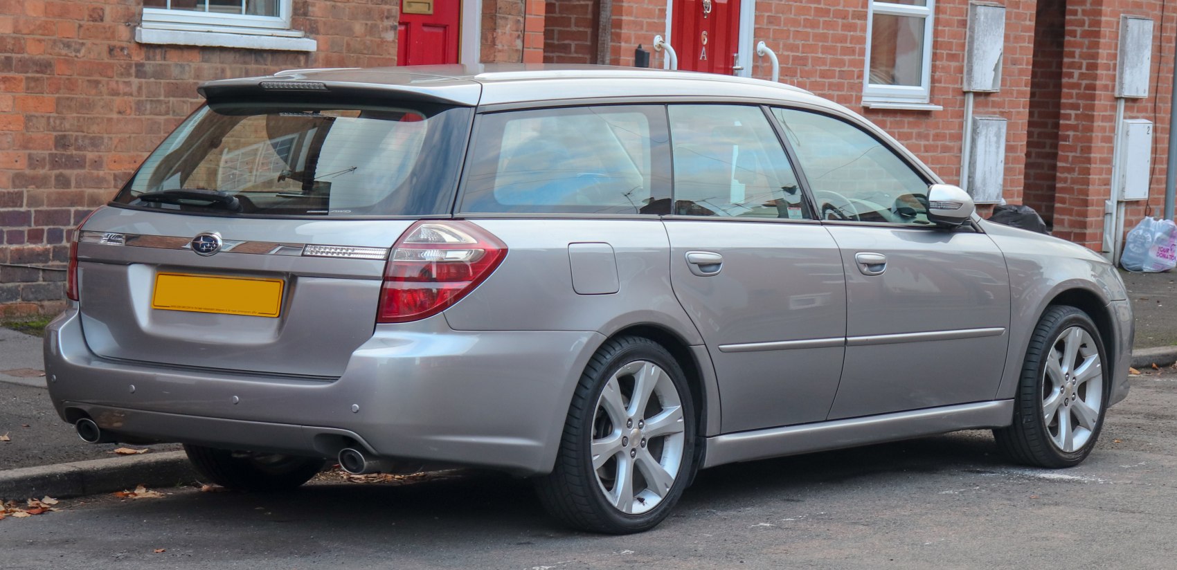 Rear and side view of a silver station wagon with dual exhaust and distinct tail lights