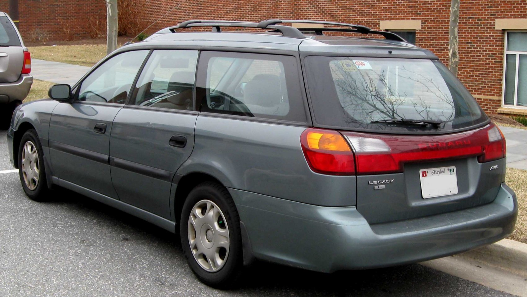 Rear and side view of station wagon with roof rails and prominent tail lights