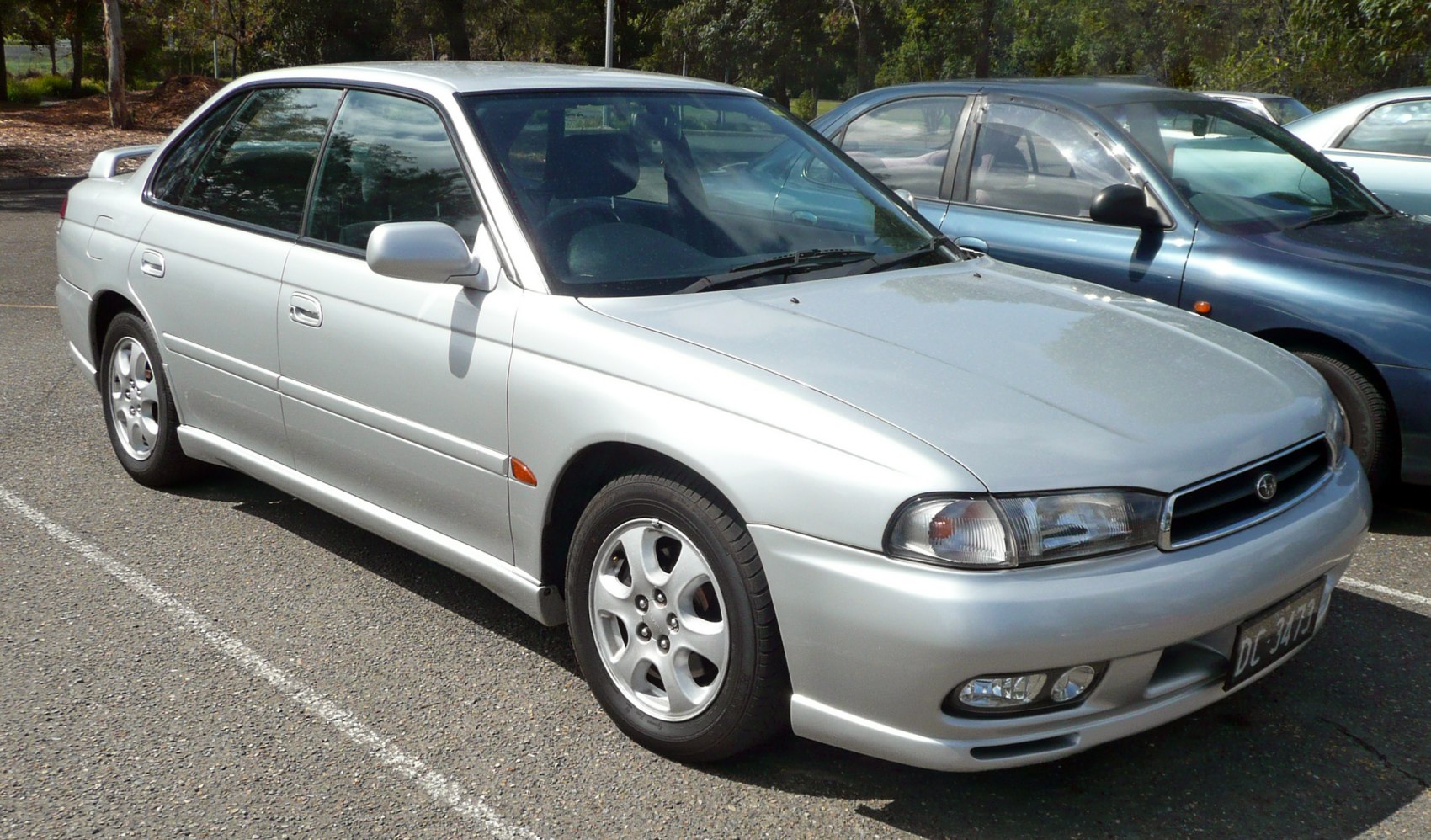Sedan front profile and alloy wheels in daylight parking