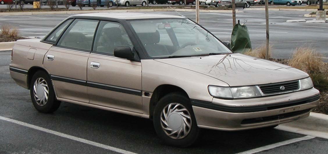 Side profile of classic 90s sedan with boxy design and alloy wheel covers