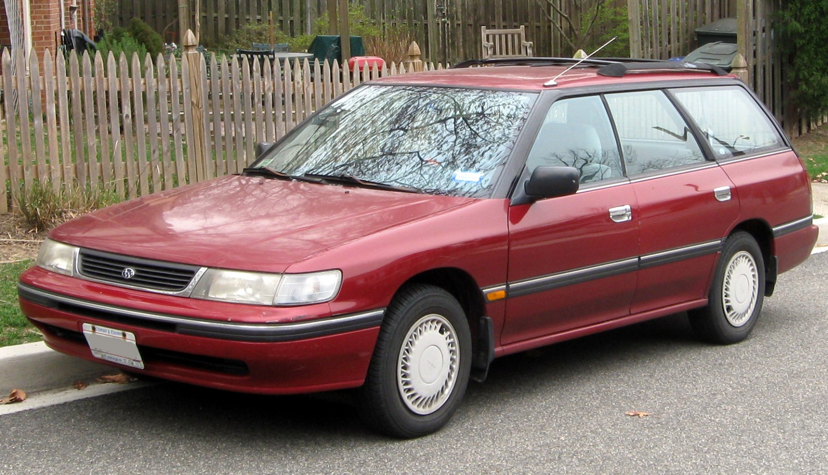 Red facelift mid-size station wagon with rectangular headlights and roof rails