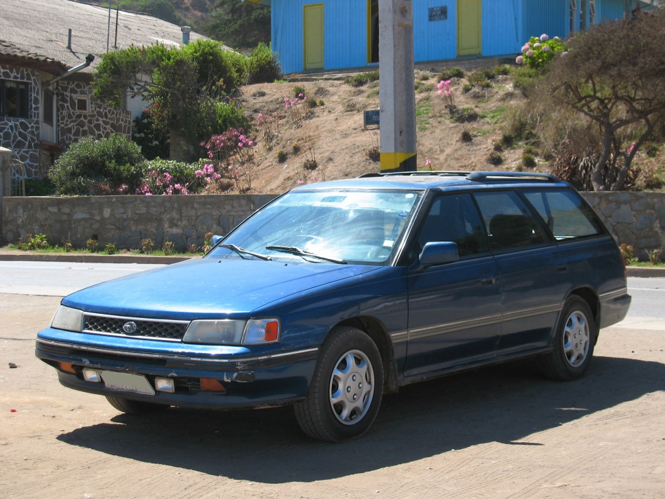 Front side view of blue vintage station wagon with roof rails.