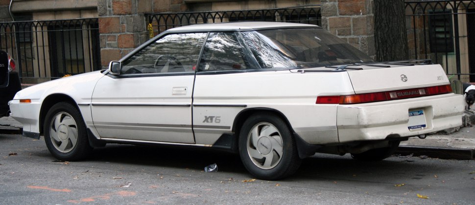 Side profile of a white vintage coupe with distinctive angular design.