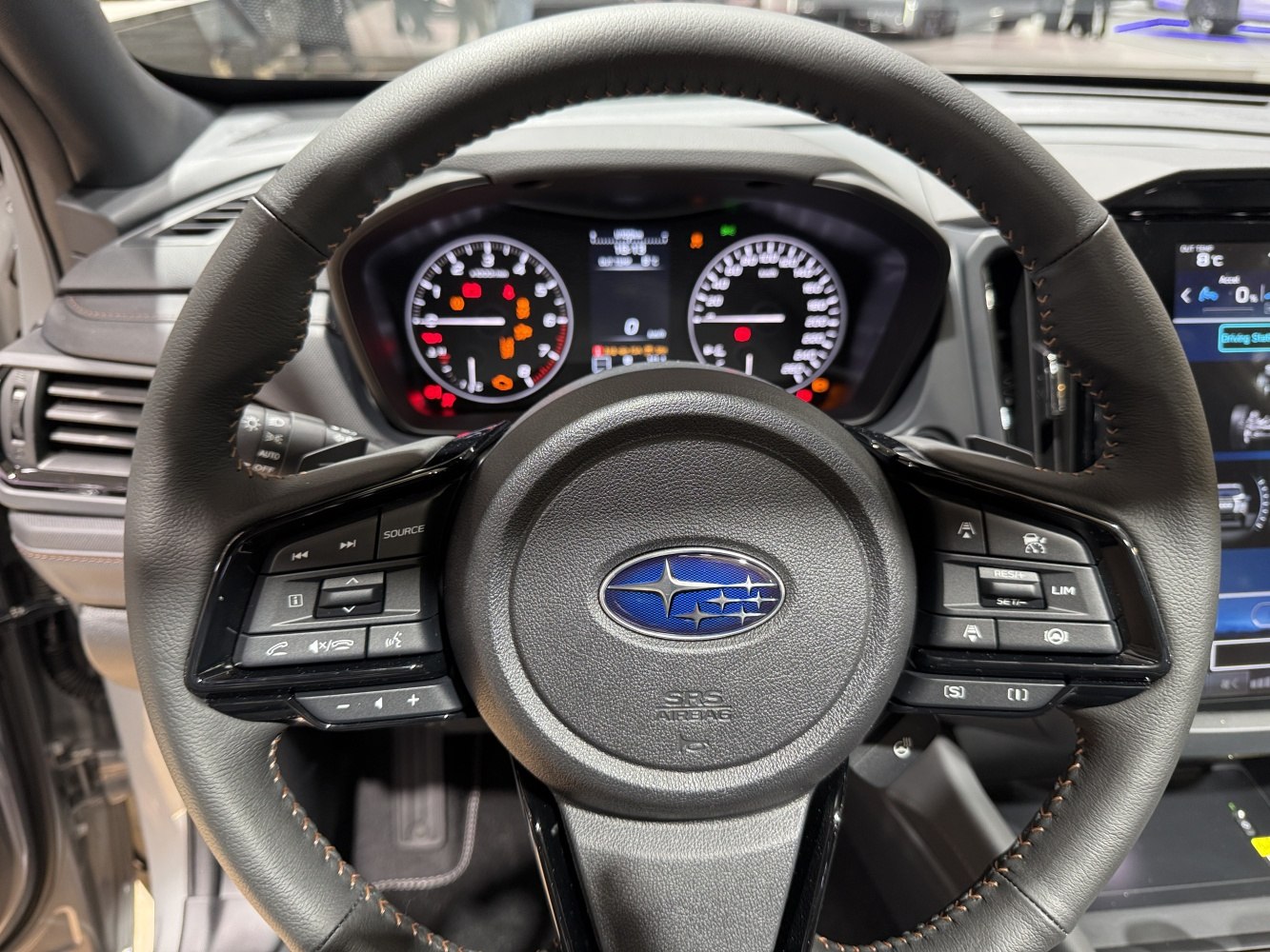 Steering wheel with controls and instrument cluster featuring gauges.