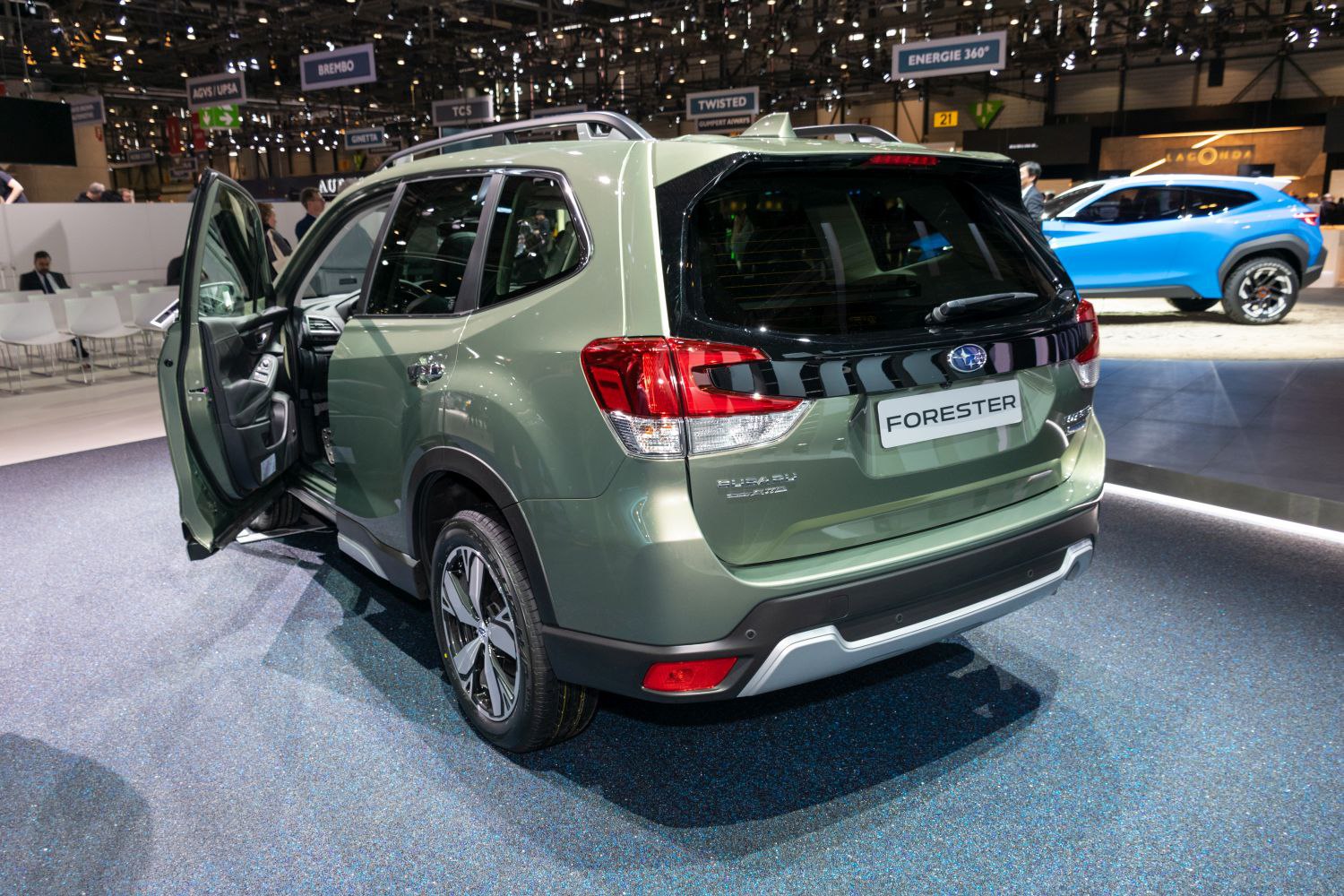 Rear view of mid-size SUV with open front door indoors