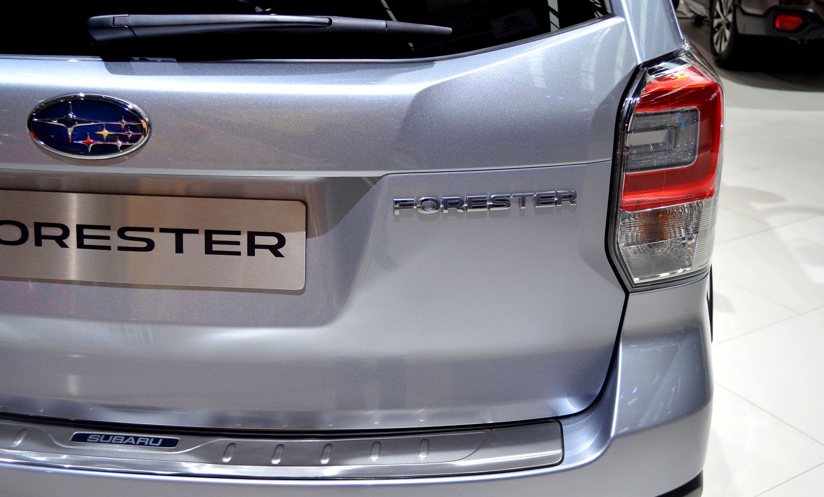 Rear tail light and Forester badge on silver hatchback